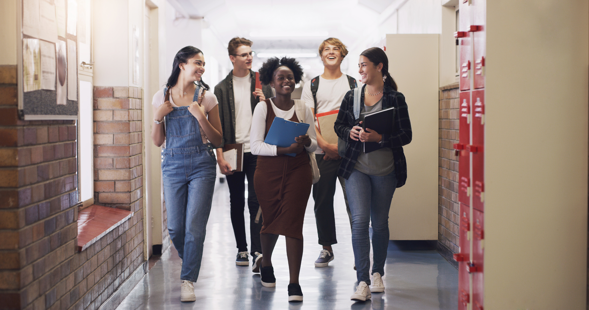 Shot of a group of teenagers walking down the hall at high school