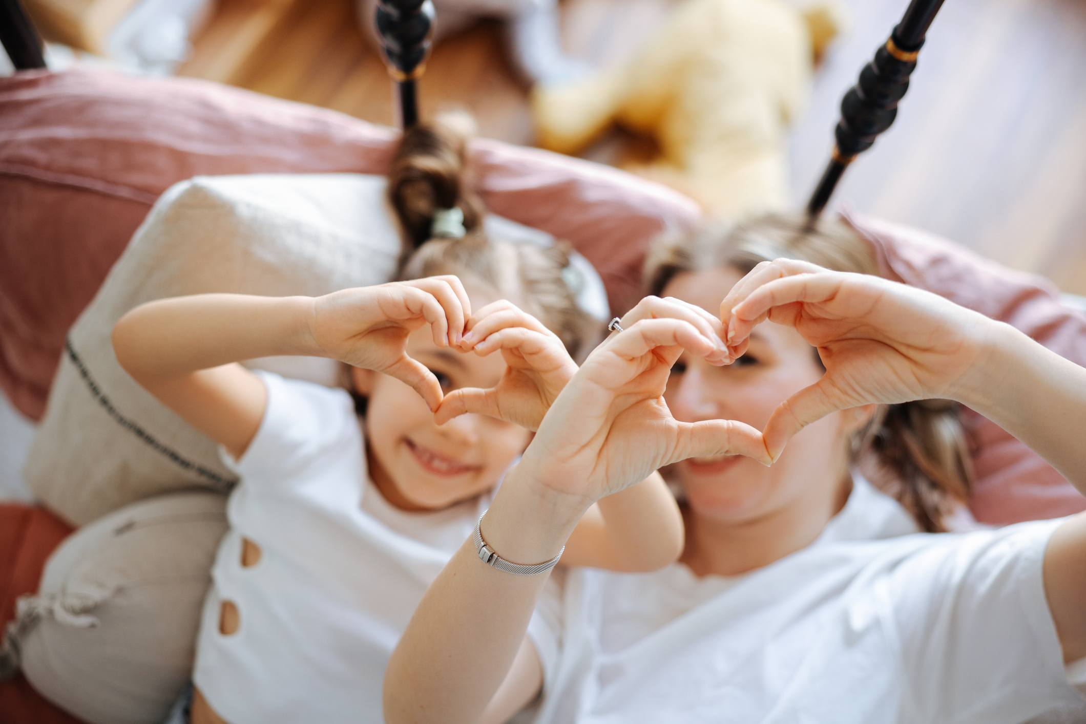 Young woman and her daughter meet in the morning in bed
